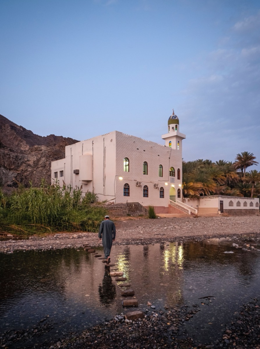 Coastal mosque at dusk near a wadi river mouth