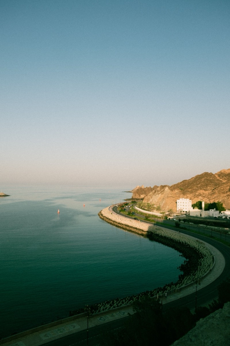 Aerial view of Oman's coastal road curving along the sea