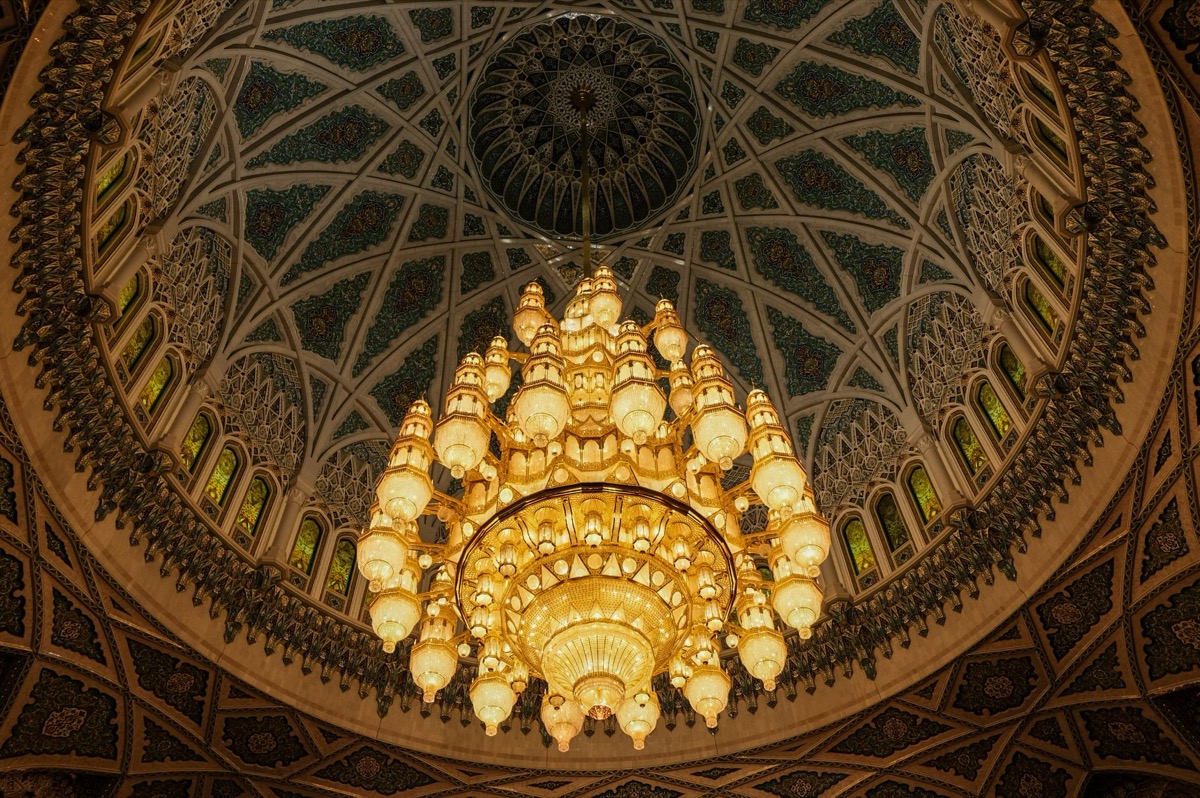 Ornate chandelier and dome ceiling inside the Sultan Qaboos Grand Mosque