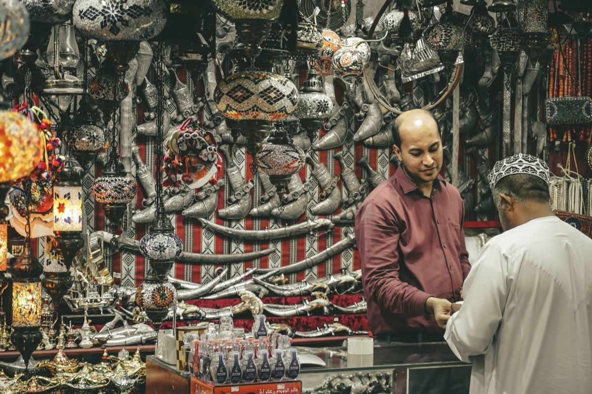 Traditional souk shop with khanjar daggers and lanterns in Muscat